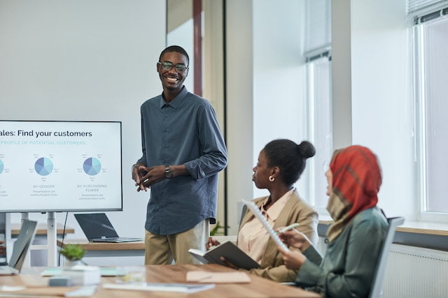 A man presenting his presentation on data analysis of there customer in-front of other team,  a Big Data Analyst Uncovering Insights and Driving Business Growth.